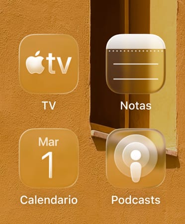 Cuadrícula de cuatro íconos translúcidos, de las apps Apple TV, Notas, Calendario y Podcasts, que refractan el fondo