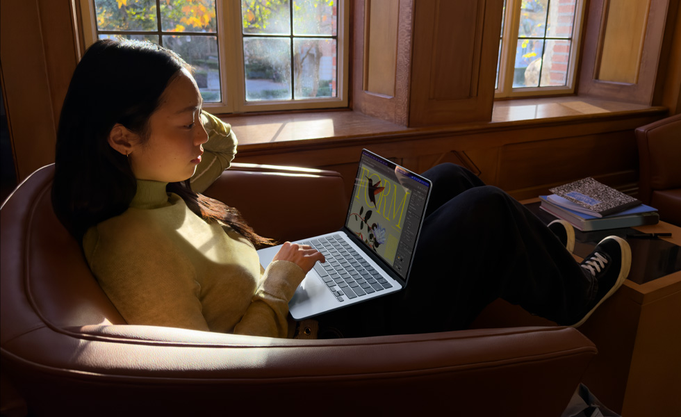 Una persona sentada en una silla usa un MacBook Air